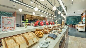 A buffet setup with various food items and utensils.
