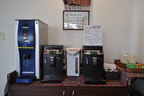 Una estación de café con tres máquinas de café y un cartel sobre el uso de la cafetera.