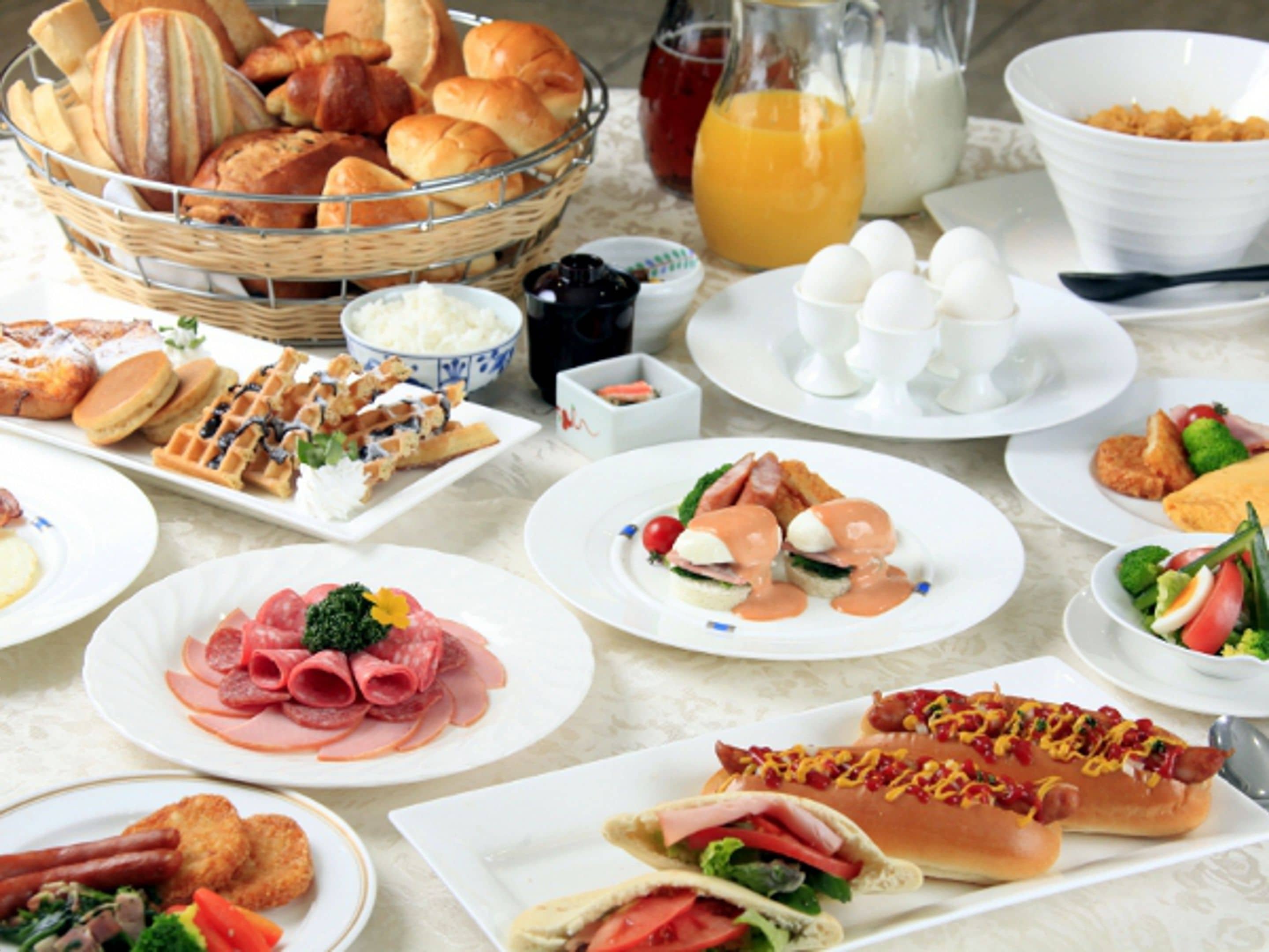 Variedad de platillos para el desayuno, como waffles, huevos y sándwiches.
