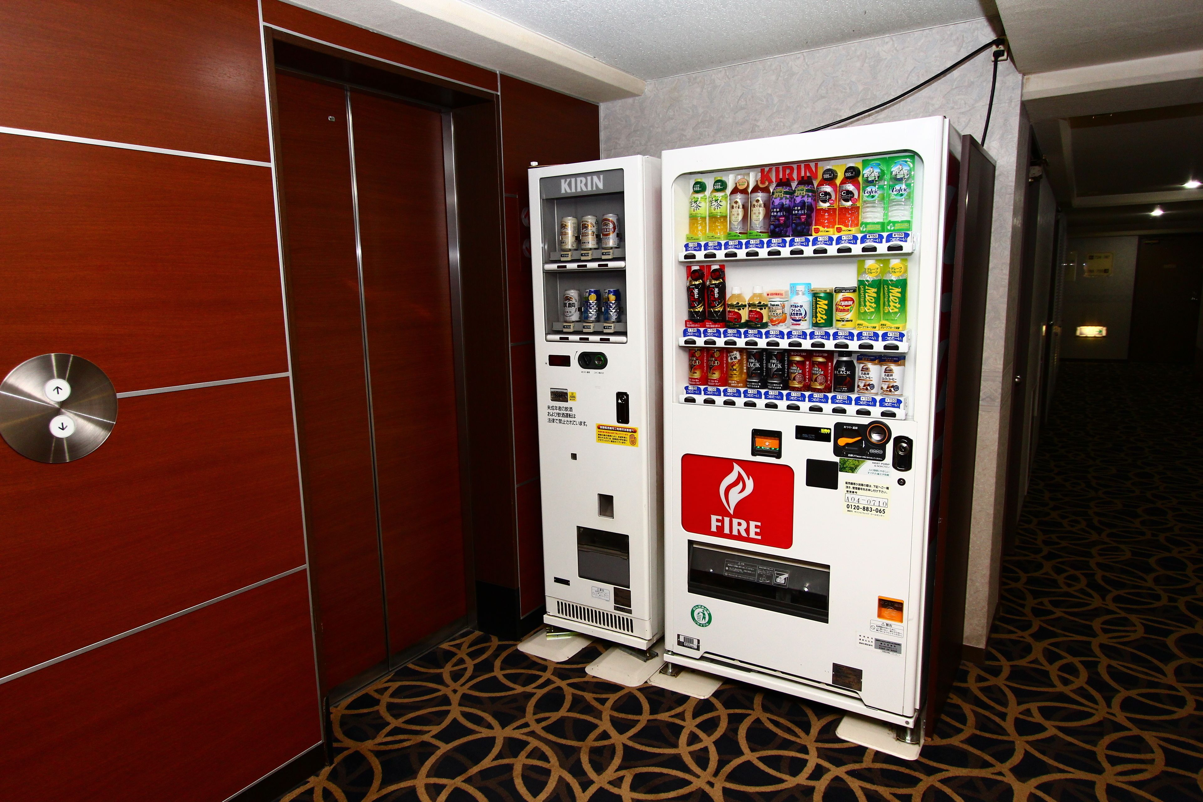 Un distributeur automatique orné du symbole d’un extincteur et proposant une variété de boissons.