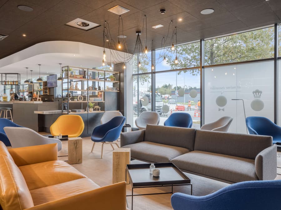 A modern interior with seating areas, a bar, and large windows.