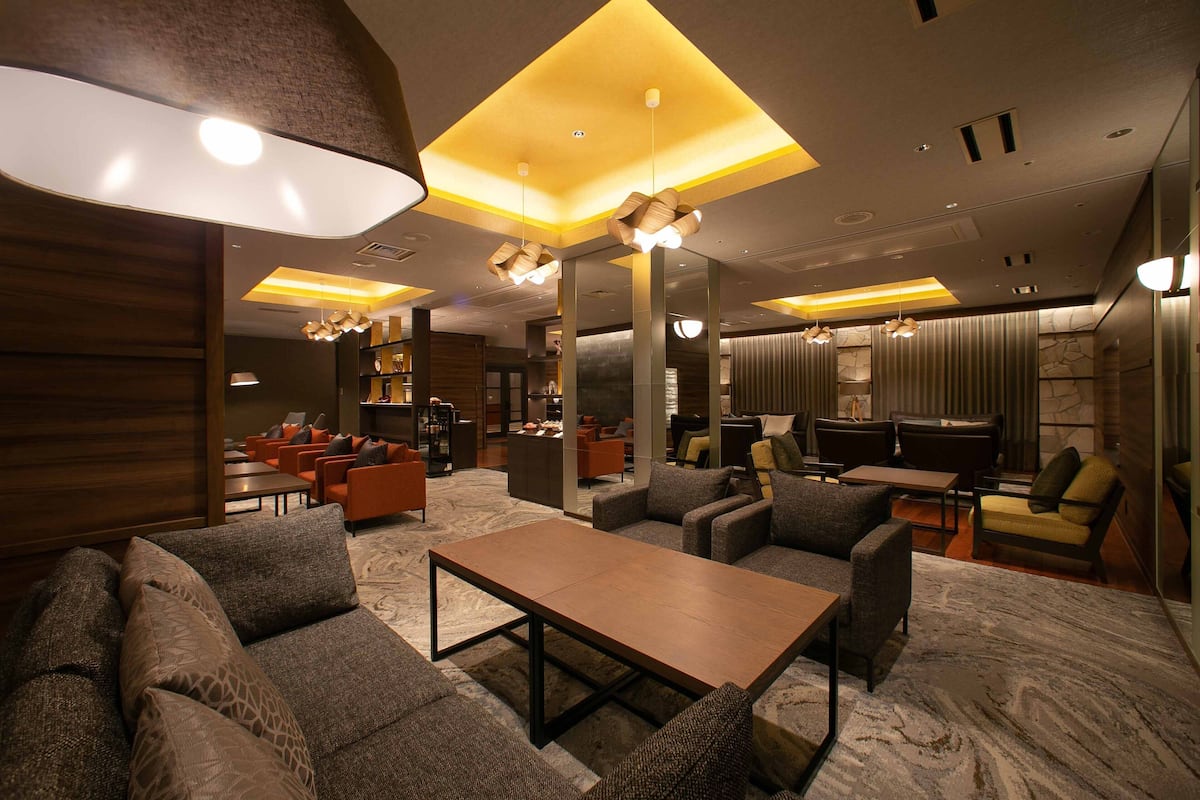 A modern lounge area with sofas, a coffee table, and ambient lighting.