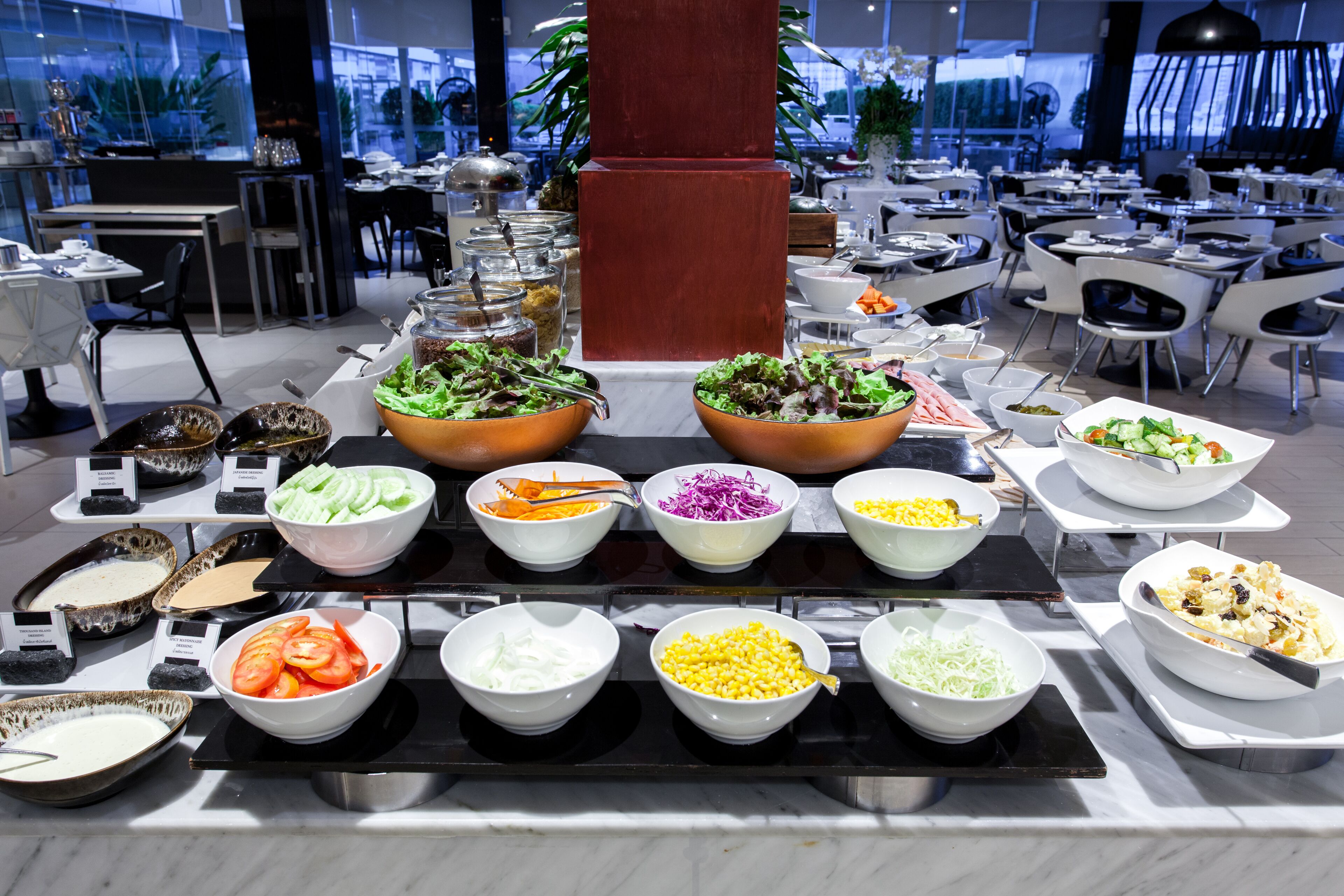 A buffet with various food options including salads, vegetables, and other dishes.