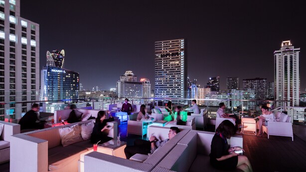 Un bar situé sur le toit d’un immeuble, avec une terrasse et une vue imprenable sur le paysage urbain.