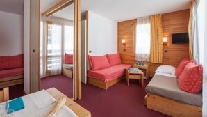 Ein Zimmer mit einem Bett, einer Couch, einem kleinen Tisch und einem Spiegel.