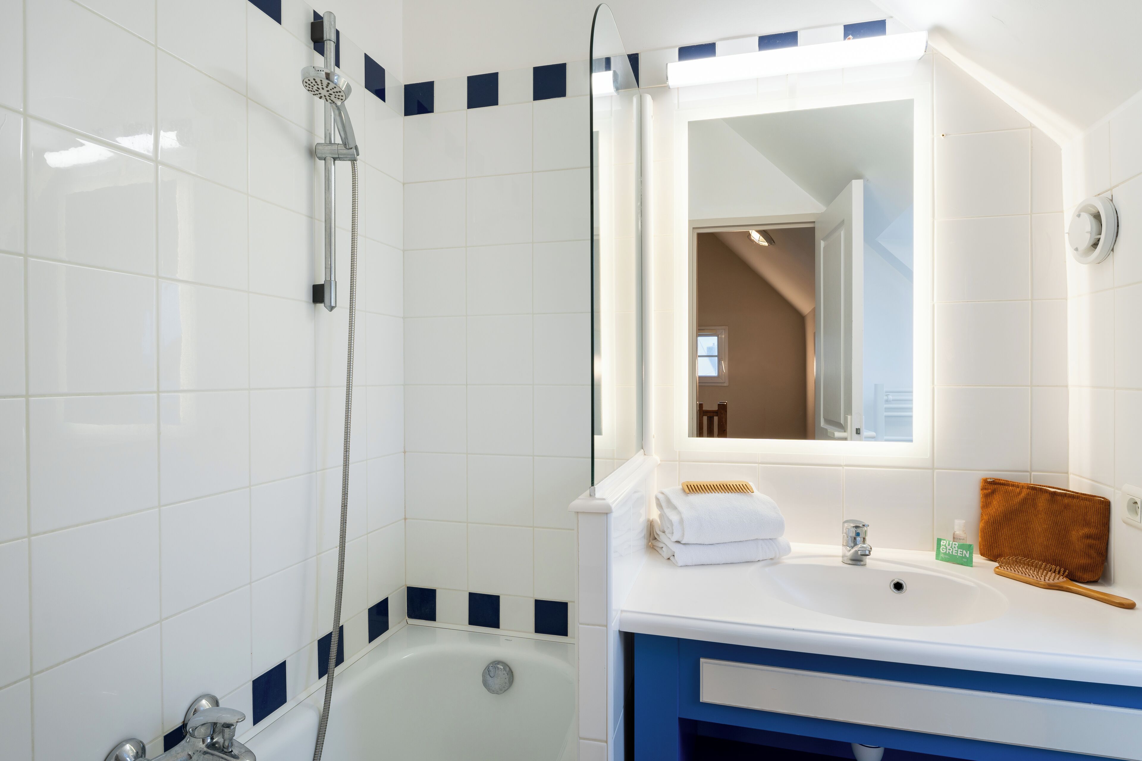Une salle de bain avec une baignoire, une douche, un lavabo et un miroir.