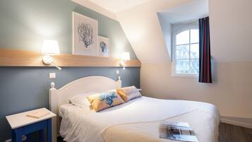 A neatly arranged bedroom with a bed, bedside tables, and artwork on the wall.