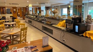 A buffet-style restaurant with a long counter, multiple seating areas, and a variety of food items displayed. - Baron Beach Hotel (Pattaya)