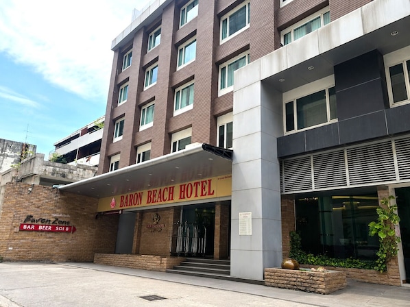 Um hotel de vários andares com um letreiro chamativo que diz 'Baron Beach Hotel'.