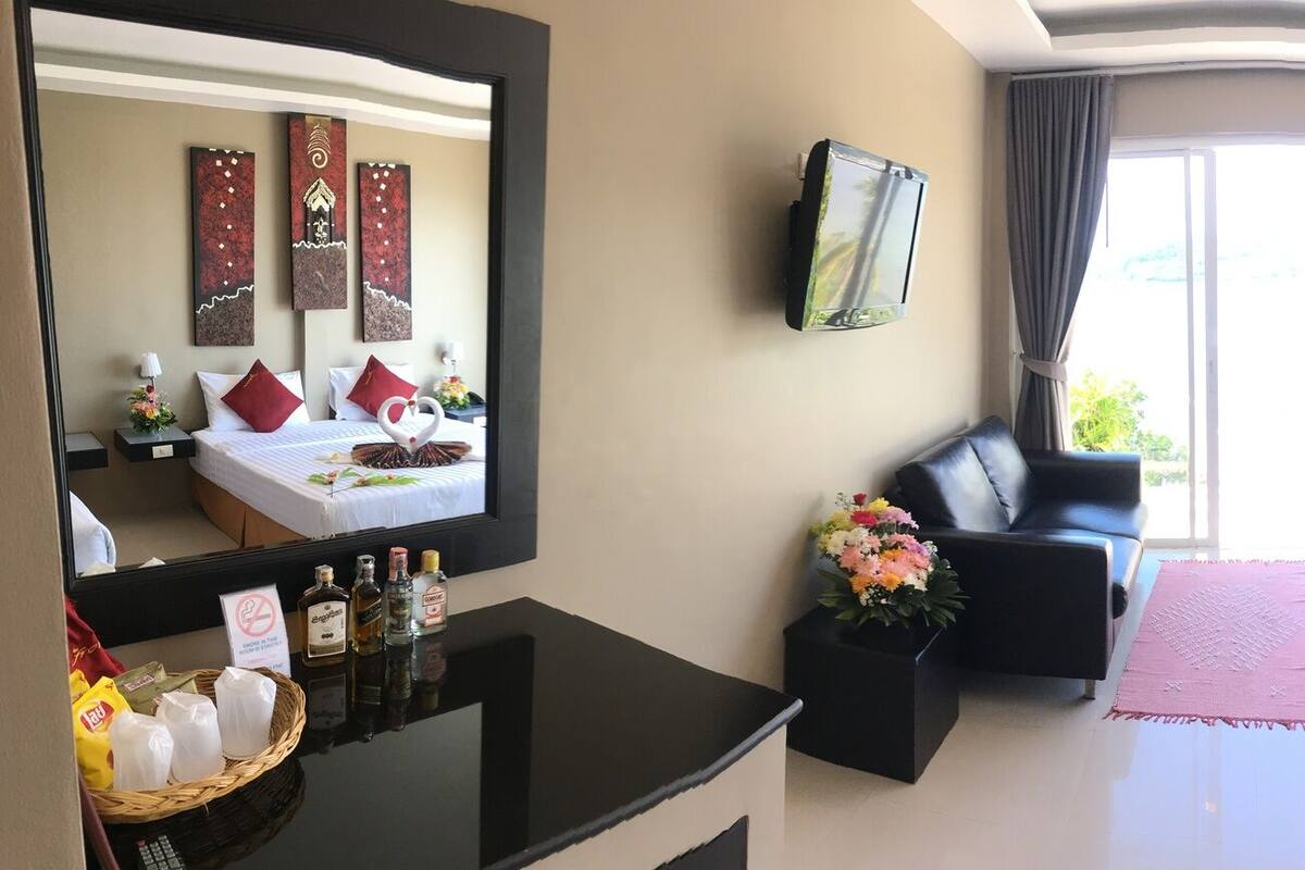 Habitación de hotel con dos camas, un espejo grande y obras de arte en las paredes.