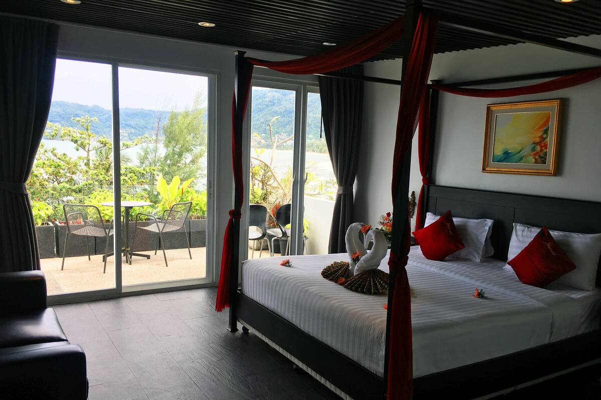 Un dormitorio con cama, un cuadro y vista a zonas verdes.