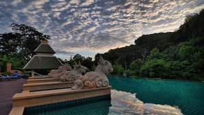 A serene pool area with stone sculptures and a clear view of the sky. - Suuko Villas (Chalong)