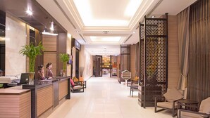 A hotel reception area with a reception desk, seating area, and decorative screens. - Mida Hotel Ngamwongwan (Nonthaburi)