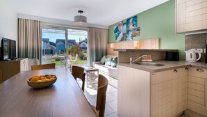 Cocina moderna con comedor, cafetera y vistas al exterior.