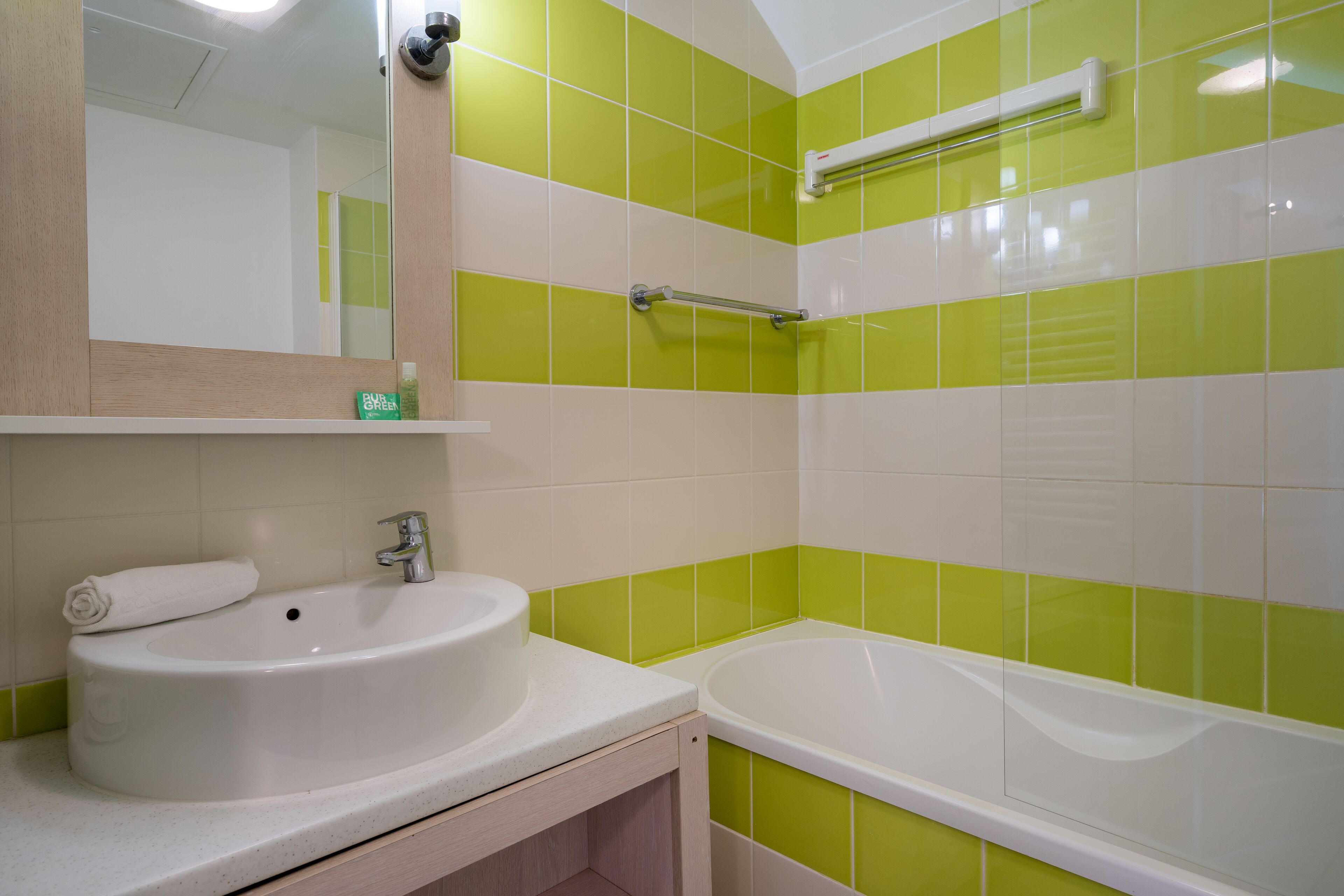 Une salle de bain avec un lavabo, un miroir et une baignoire.