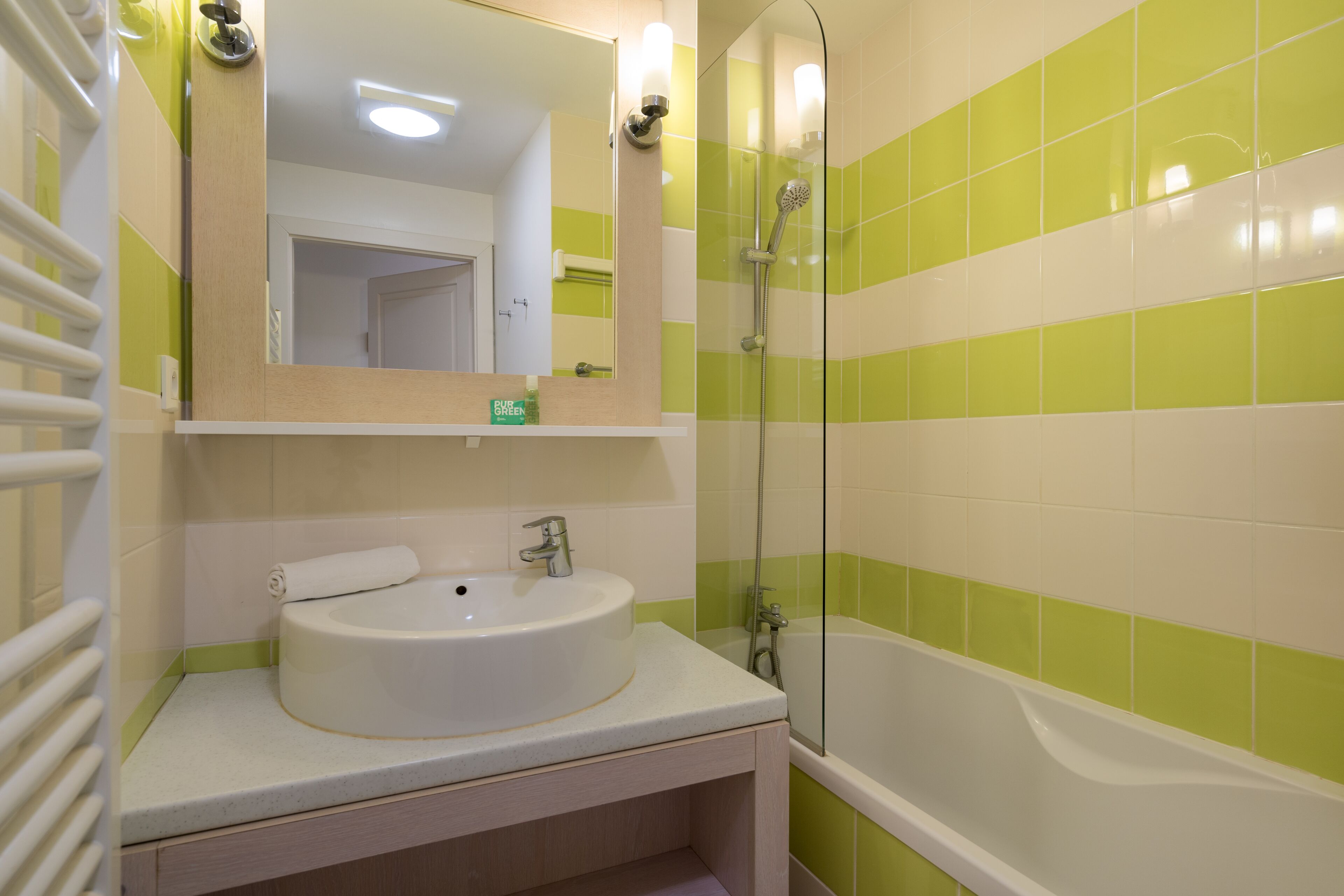 Une salle de bain avec un lavabo, un miroir et une douche.