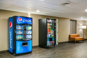 Zona de máquinas expendedoras con refrigeradores de Pepsi y Gatorade, un banco y una puerta en el vestíbulo de un hotel.