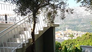 A staircase leading to a building with a view of a cityscape in the background. - Accommodation Drasko (Korcula)