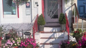 A building with a red awning labeled "All Rooms en suite" and "Berkeley Tel. 418201".