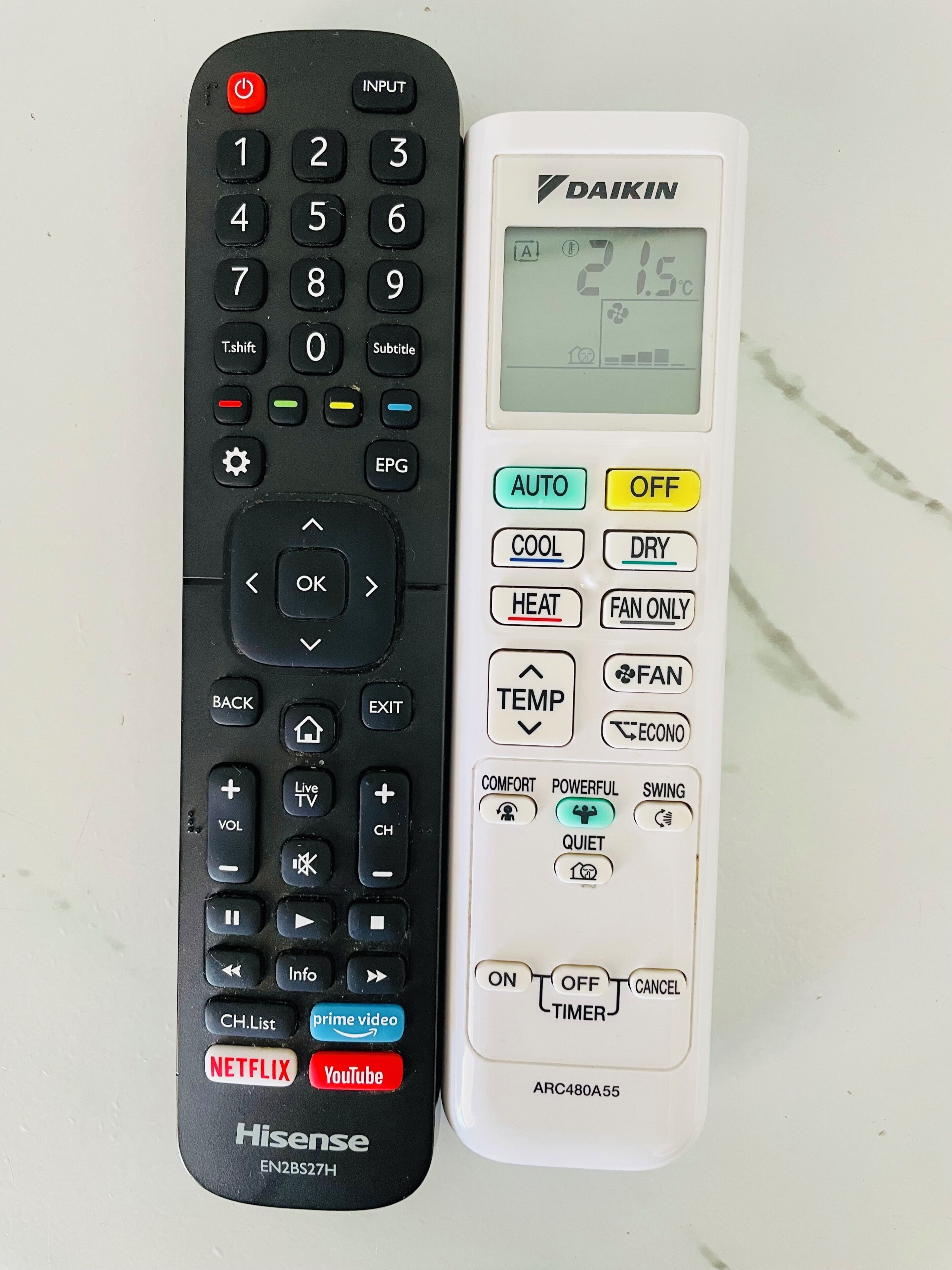 Two remote controls, one Hisense and one DAIKIN, with various buttons and functions.