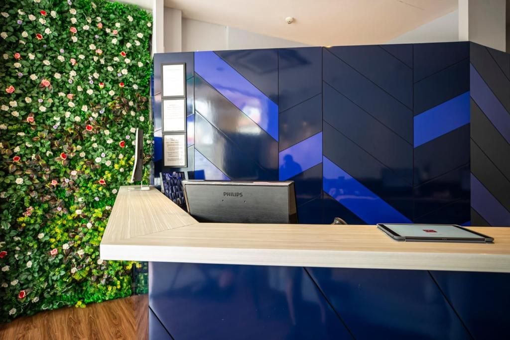 A reception desk with a wooden counter, a Philips device, and a tablet.