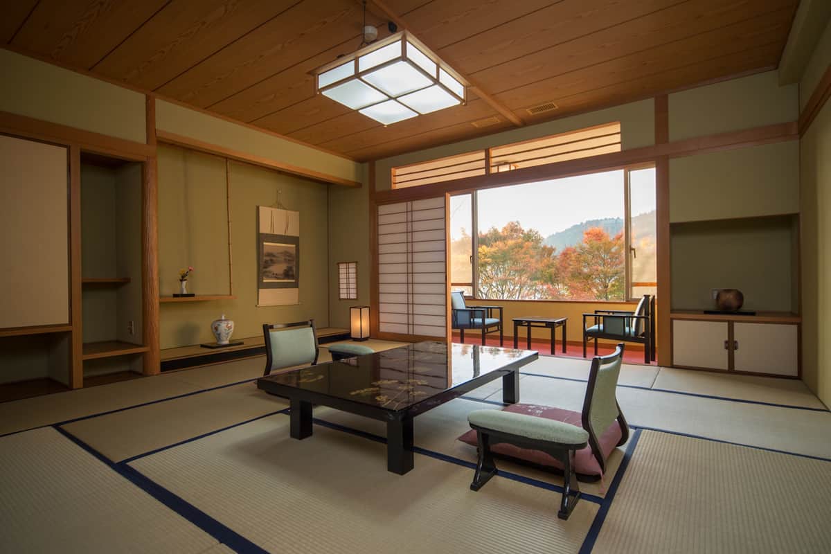 A traditional Japanese room with tatami flooring, a low table, and sliding doors.