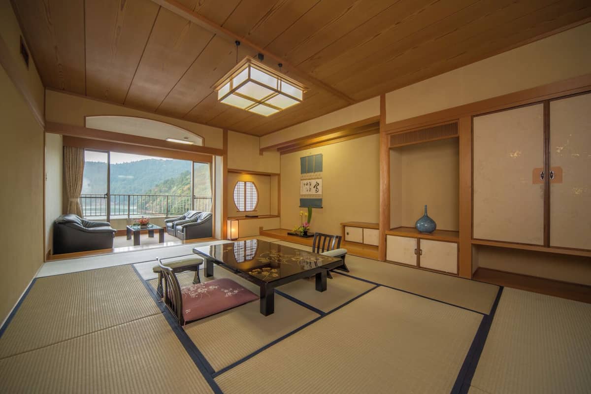 A traditional Japanese-style room with tatami flooring, a low table, and a sofa.