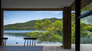 Une chambre avec vue sur un lac et une forêt.