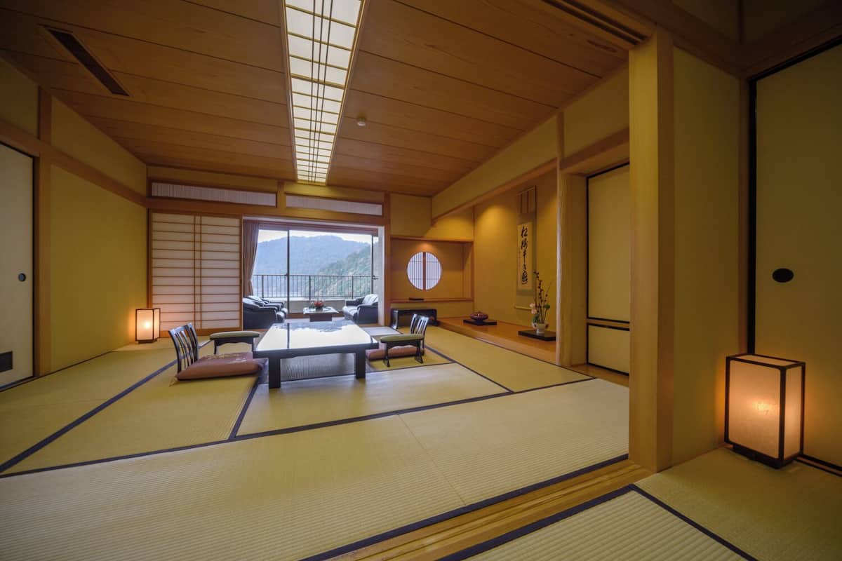 A traditional Japanese room with tatami flooring, a low table, and cushions.