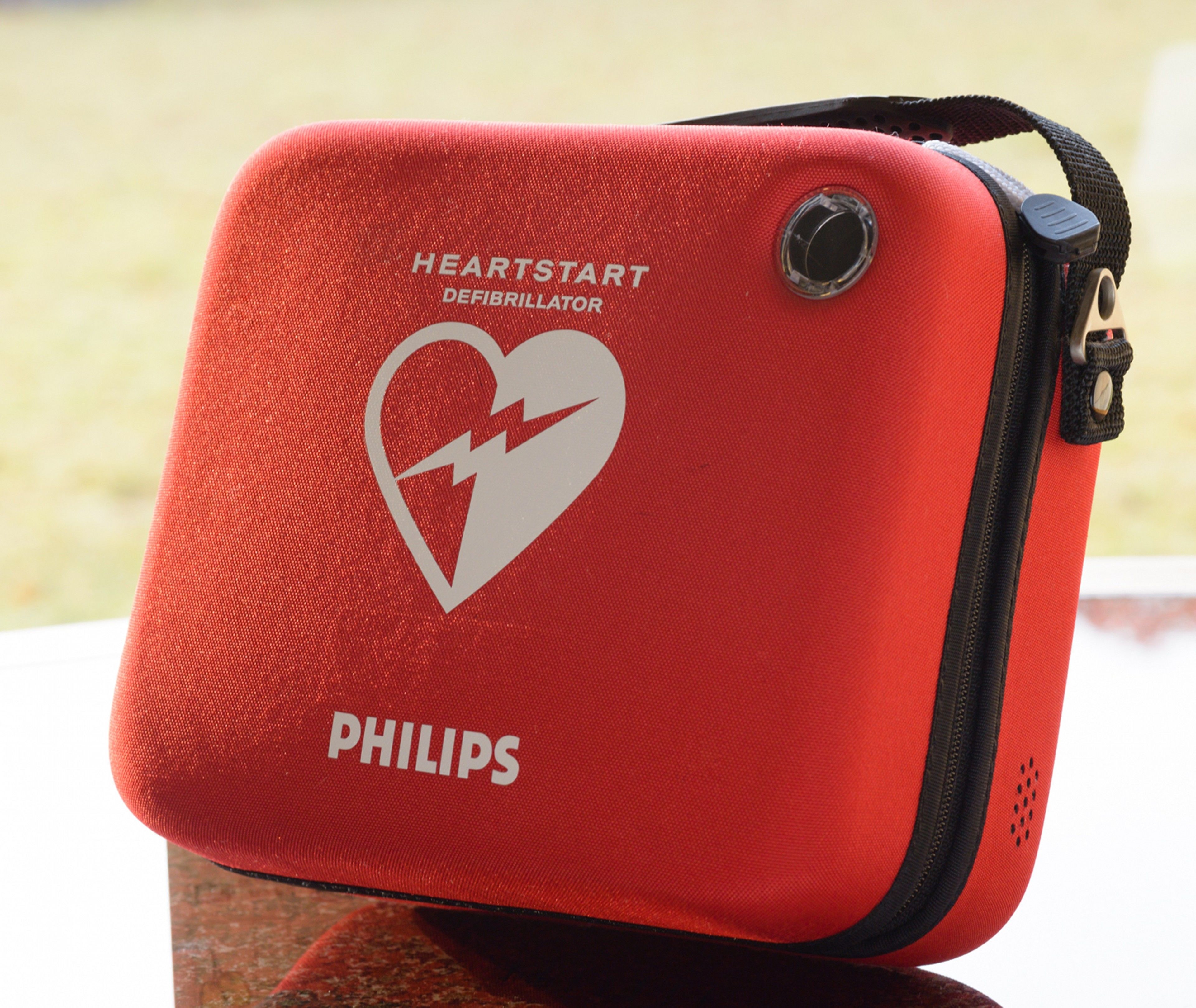 A red Philips defibrillator bag with a heart symbol and text.