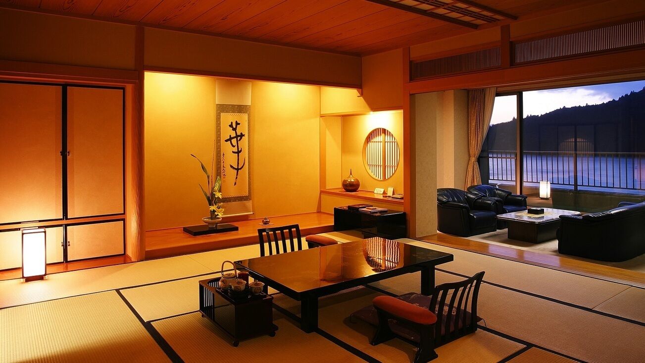 A traditional Japanese-style room with tatami flooring, a low table, and seating.