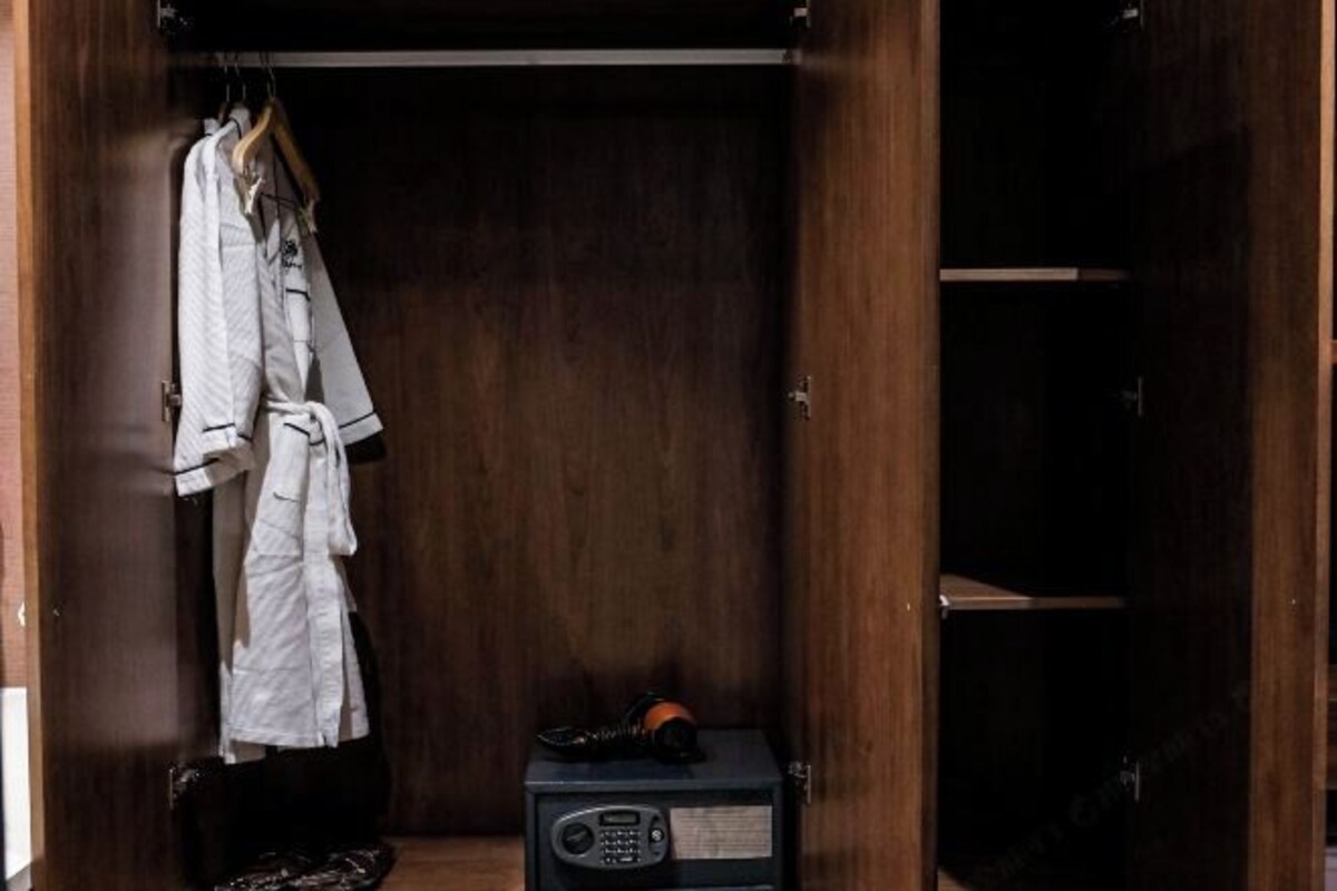 Een houten garderobe met een kledingroede en een radio.