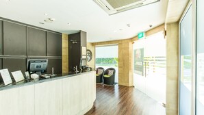 A reception area with a counter, a computer, and two chairs.