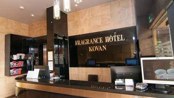 Welcome to Fragrance Hotel Kovan, where guests can check in at the reception desk featuring a computer and cash register.