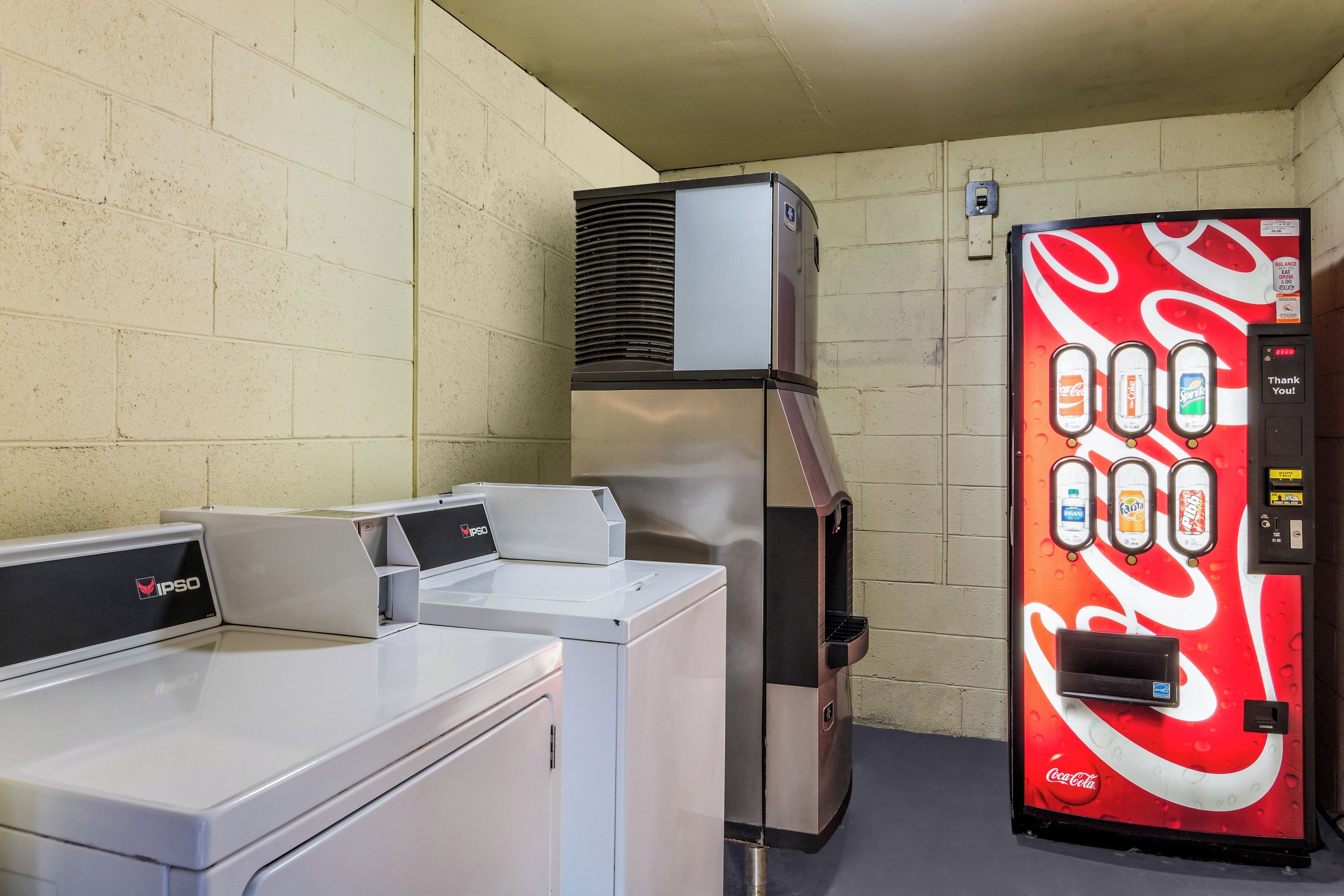 A laundromat with a vending machine and a dryer.