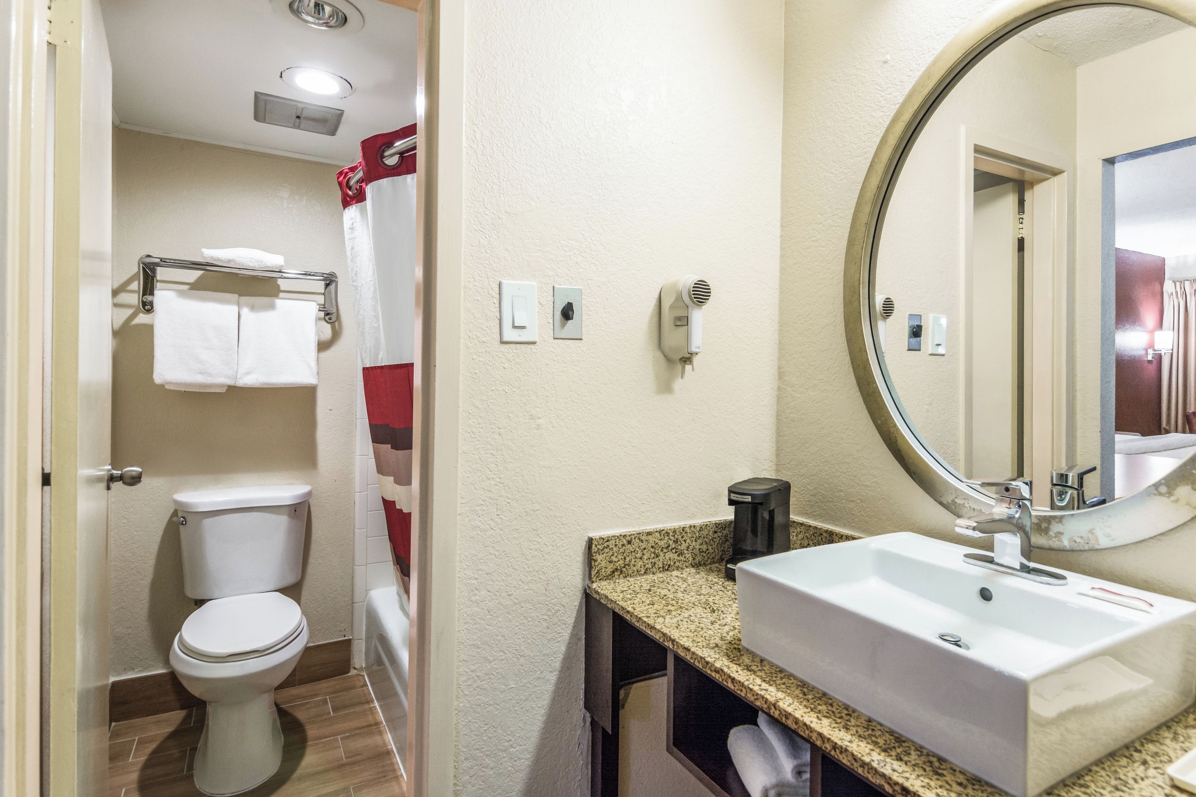 A bathroom with a toilet, sink, and shower.