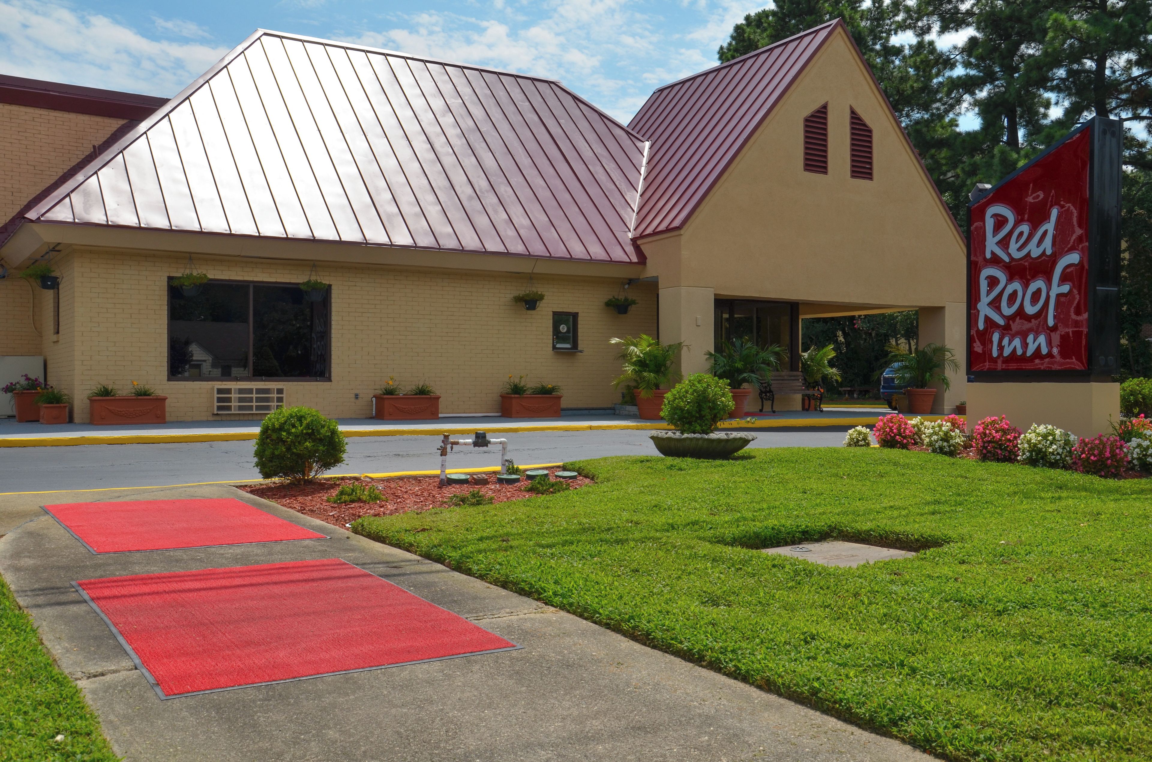 A Red Roof Inn with a red roof, beige walls, and a red carpeted entrance.