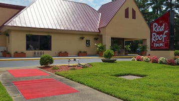 A Red Roof Inn with a red roof, beige walls, and a red carpeted entrance.