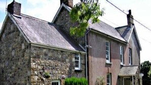 A stone house with a gabled roof, a small window, and a door. - Llysyfran Farm B&B (Clarbeston Road)