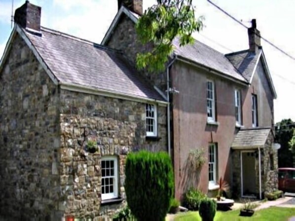 A stone house with a gabled roof, a small window, and a door. - Llysyfran Farm B&B (Clarbeston Road)