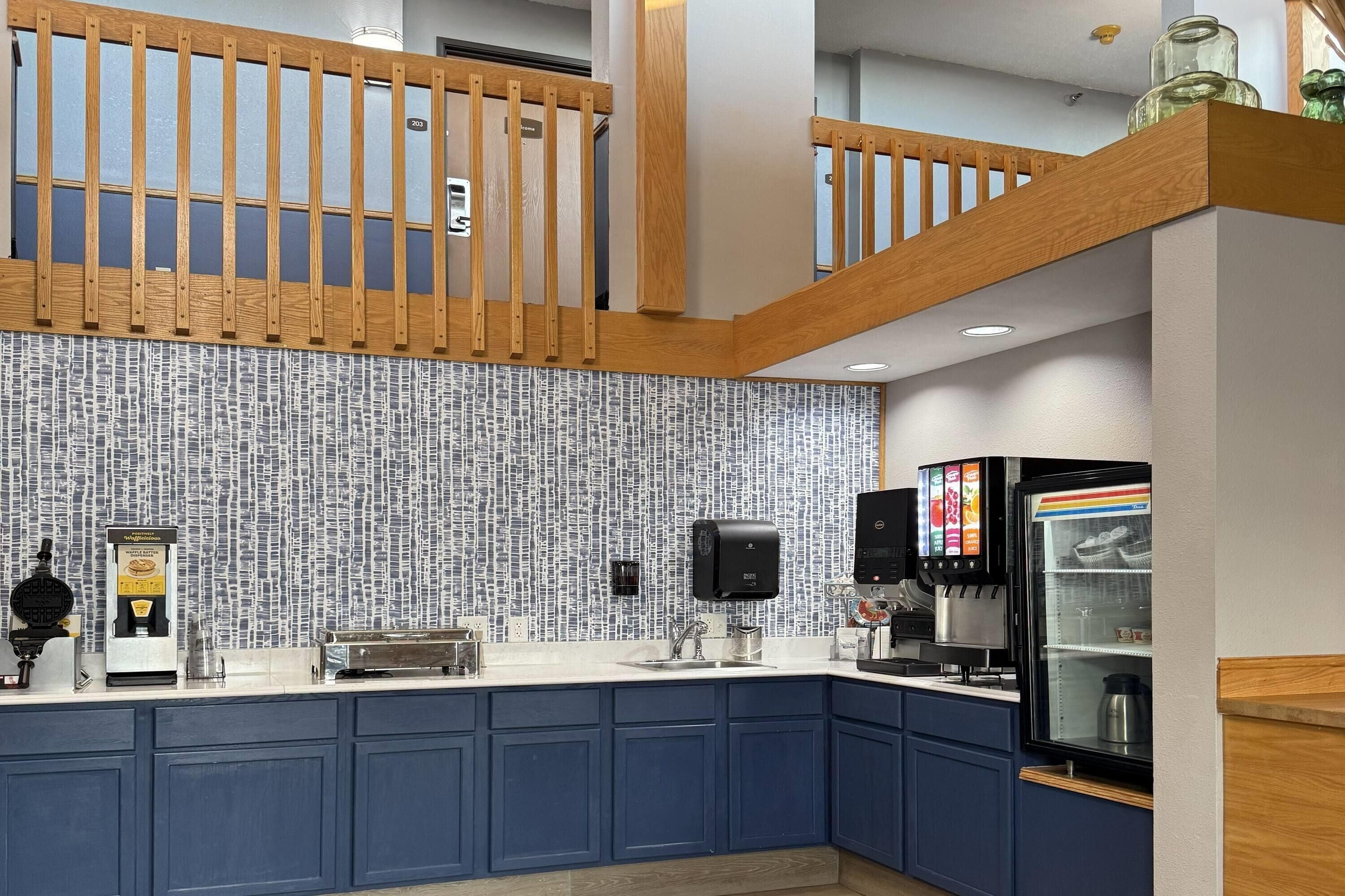 Una cocina moderna con un salpicadero estampado, una cafetera y un refrigerador.