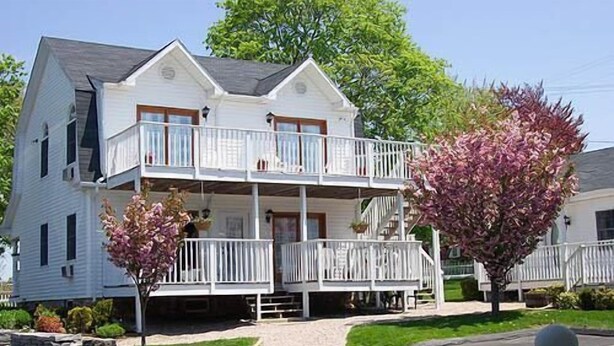 A two-story house with a balcony on the second floor. - The Taber Inne & Suites (Mystic)