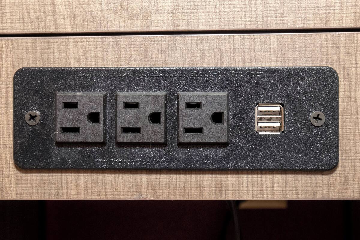 Eine wandmontierte Steckdose mit drei Standardsteckplätzen und einem USB-Anschluss.