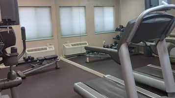 A gym with exercise equipment including treadmills and a rowing machine.
