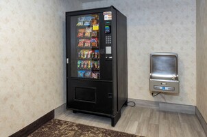 Una máquina expendedora con refrigerios y una máquina que funciona con monedas.