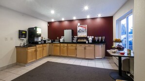 Una cucina moderna con mobili in legno, una macchina per caffè integrata e una finestra con vista all'esterno.