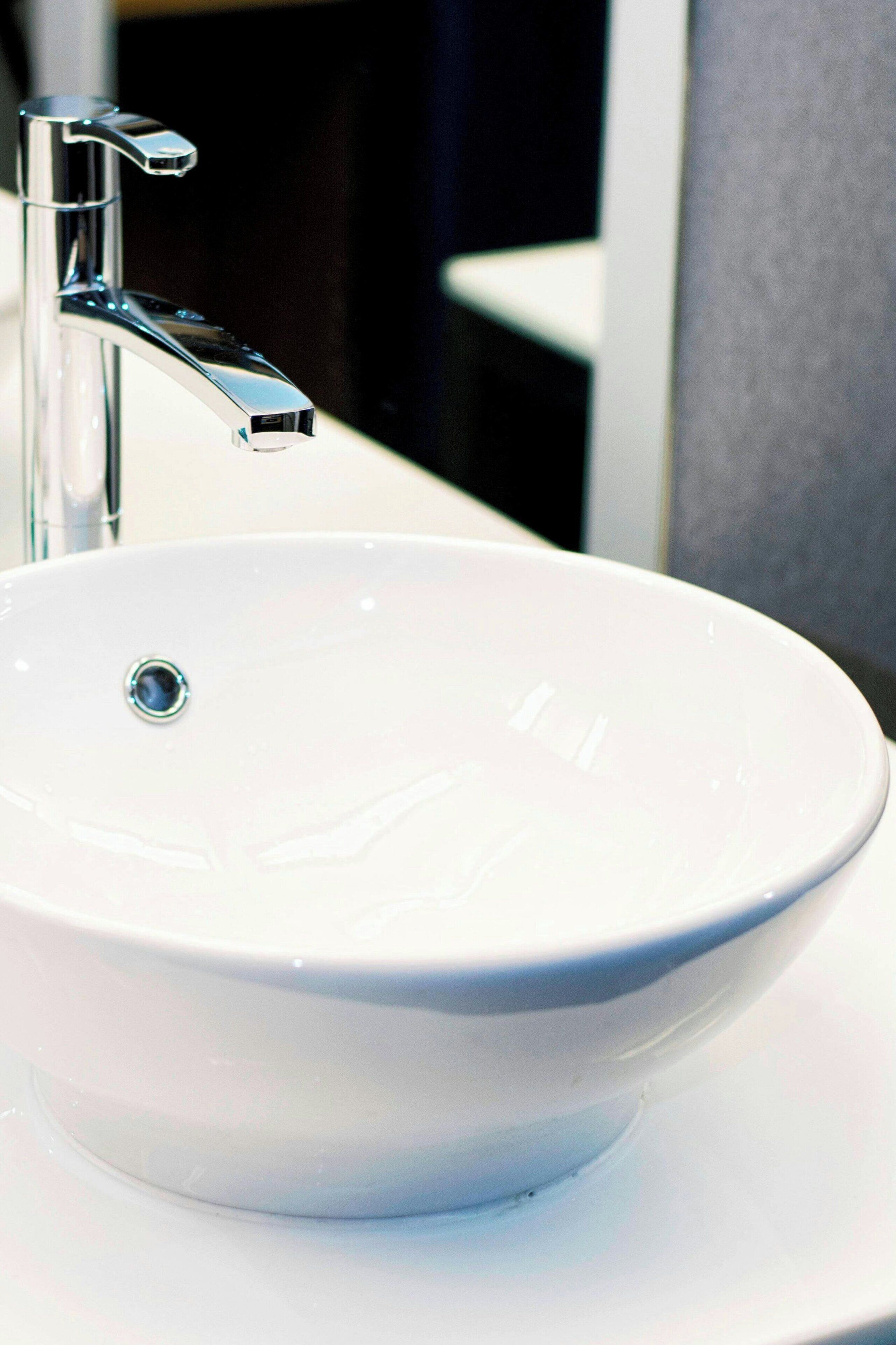 A white ceramic sink with a chrome faucet in a bathroom.