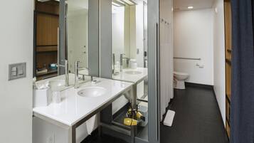 Ein modernes Badezimmer mit zwei Waschbecken, einem Spiegel und einer Toilette.