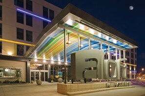 A modern hotel with a large 'HOTEL' sign, a glass facade, and a colorful striped awning. - Aloft by Marriott Miami Doral (Miami)