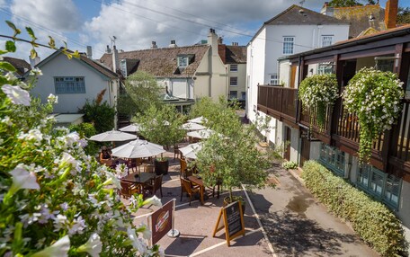A courtyard with outdoor seating, surrounded by buildings with traditional architecture.